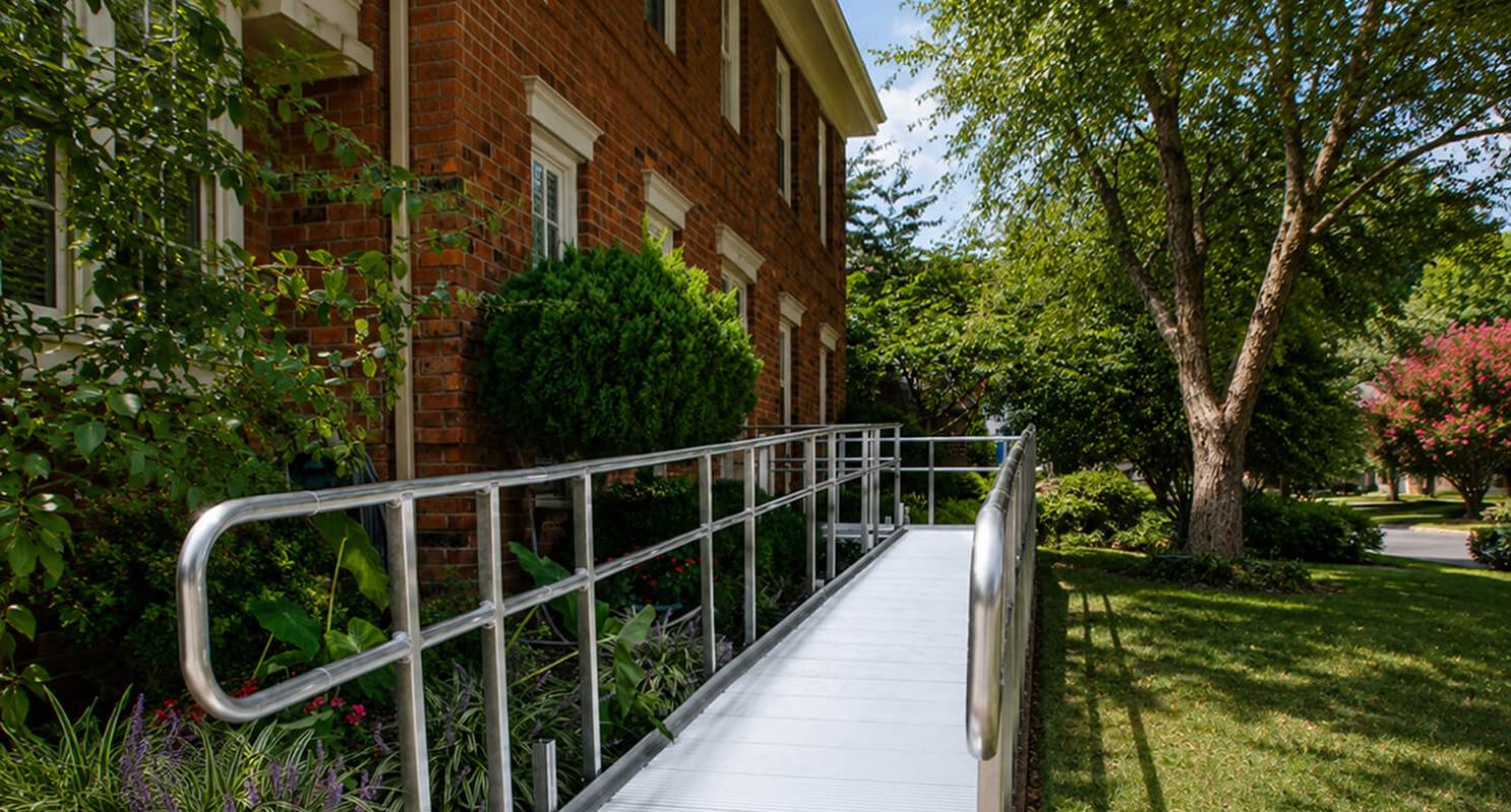 A modular ramp routed around an existing porch, with a level landing at the door.